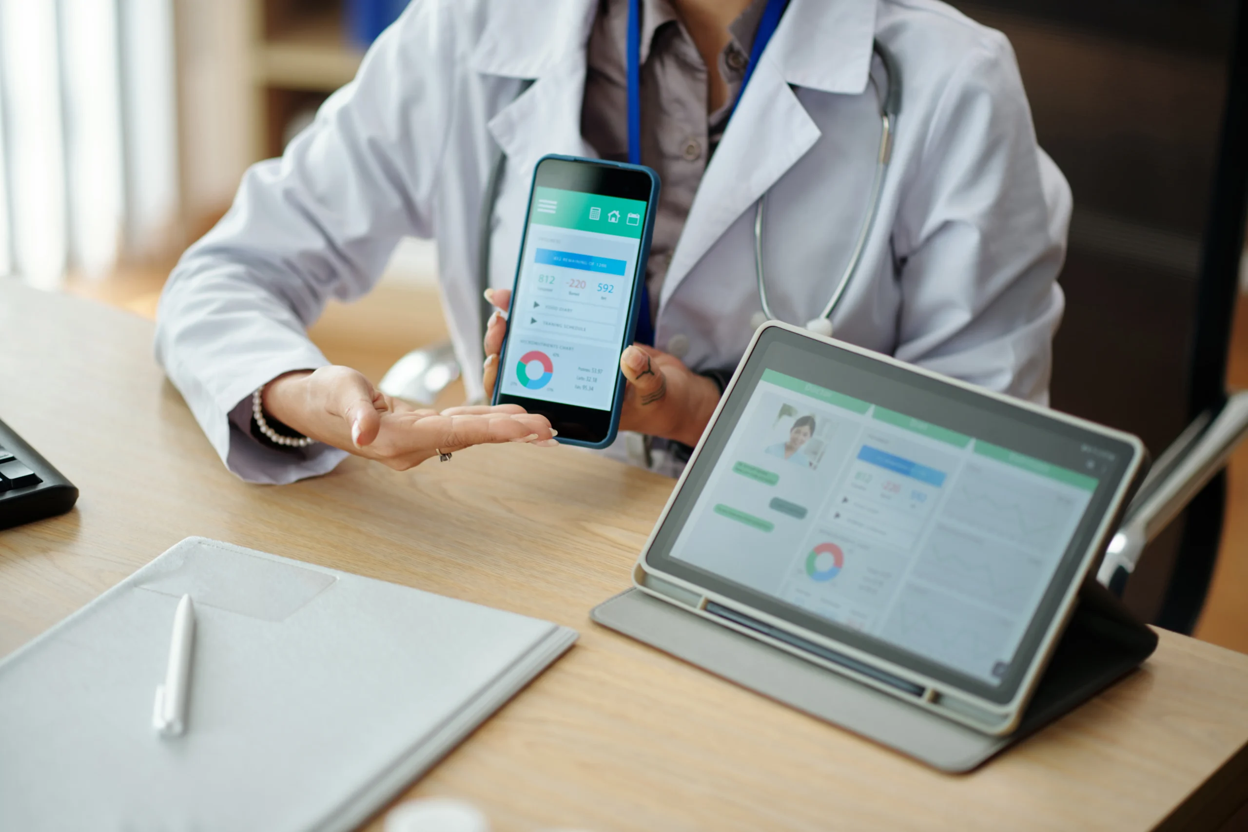 A doctor showing patient metrics on a smartphone and tablet using a prescription safety API.