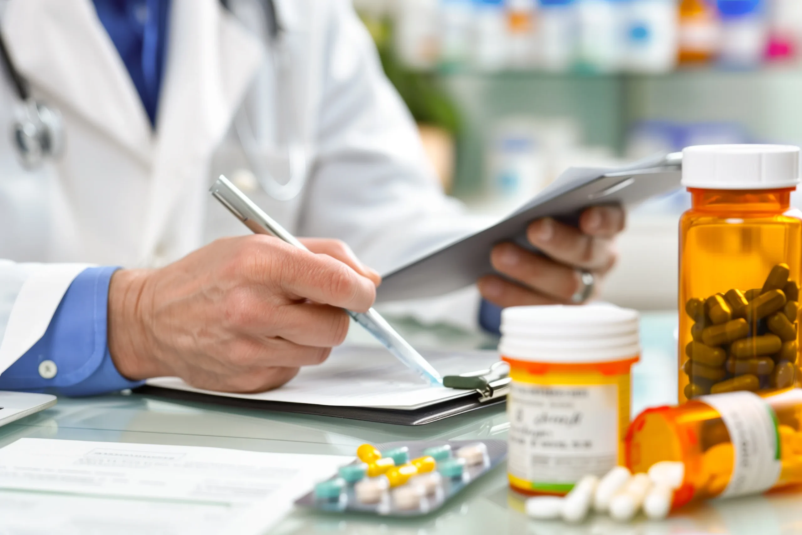 Doctor taking clinical notes at a desk near prescription bottles integrated with healthcare APIs.