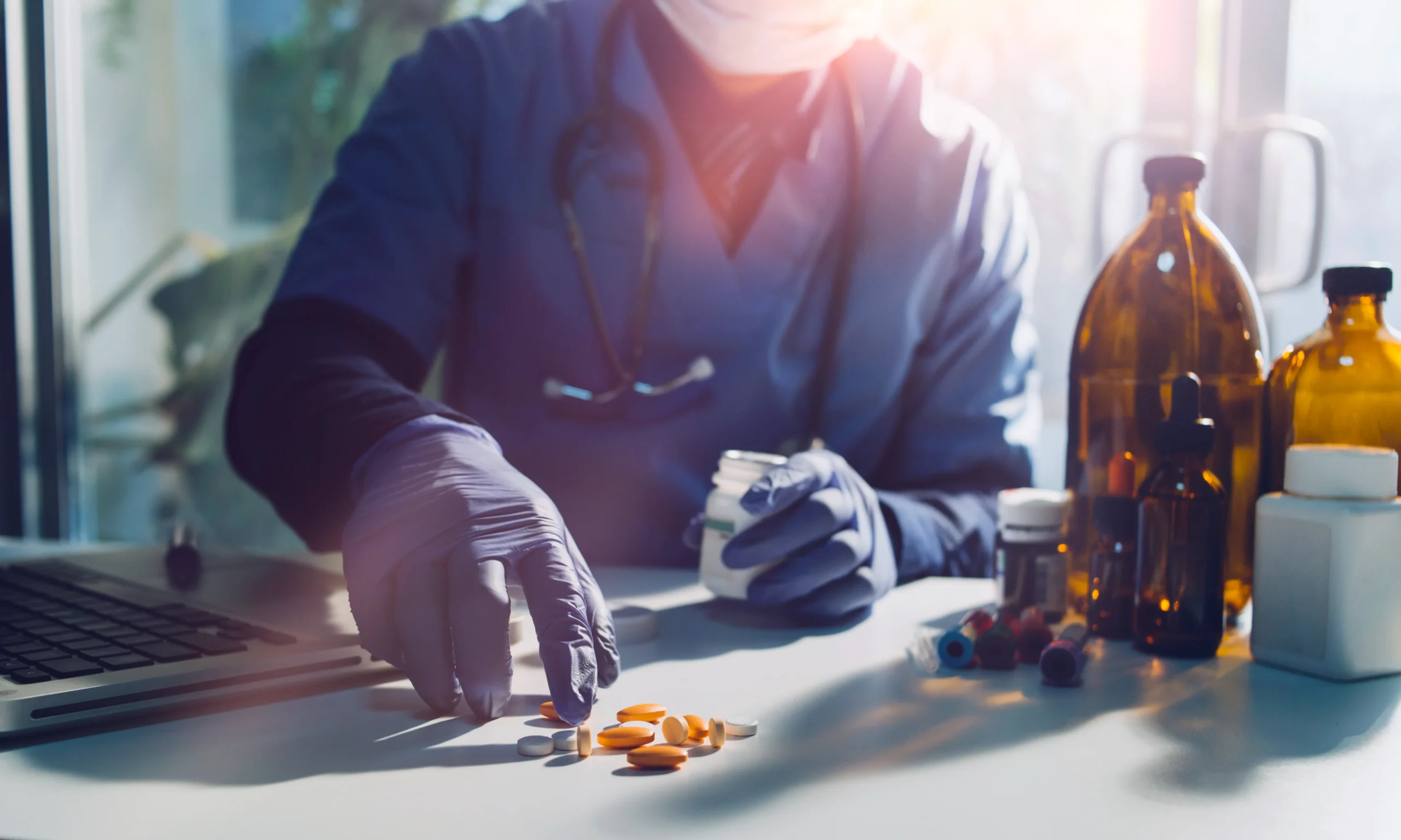 Healthcare worker sorting medication while accessing digital drug information through a medication API.