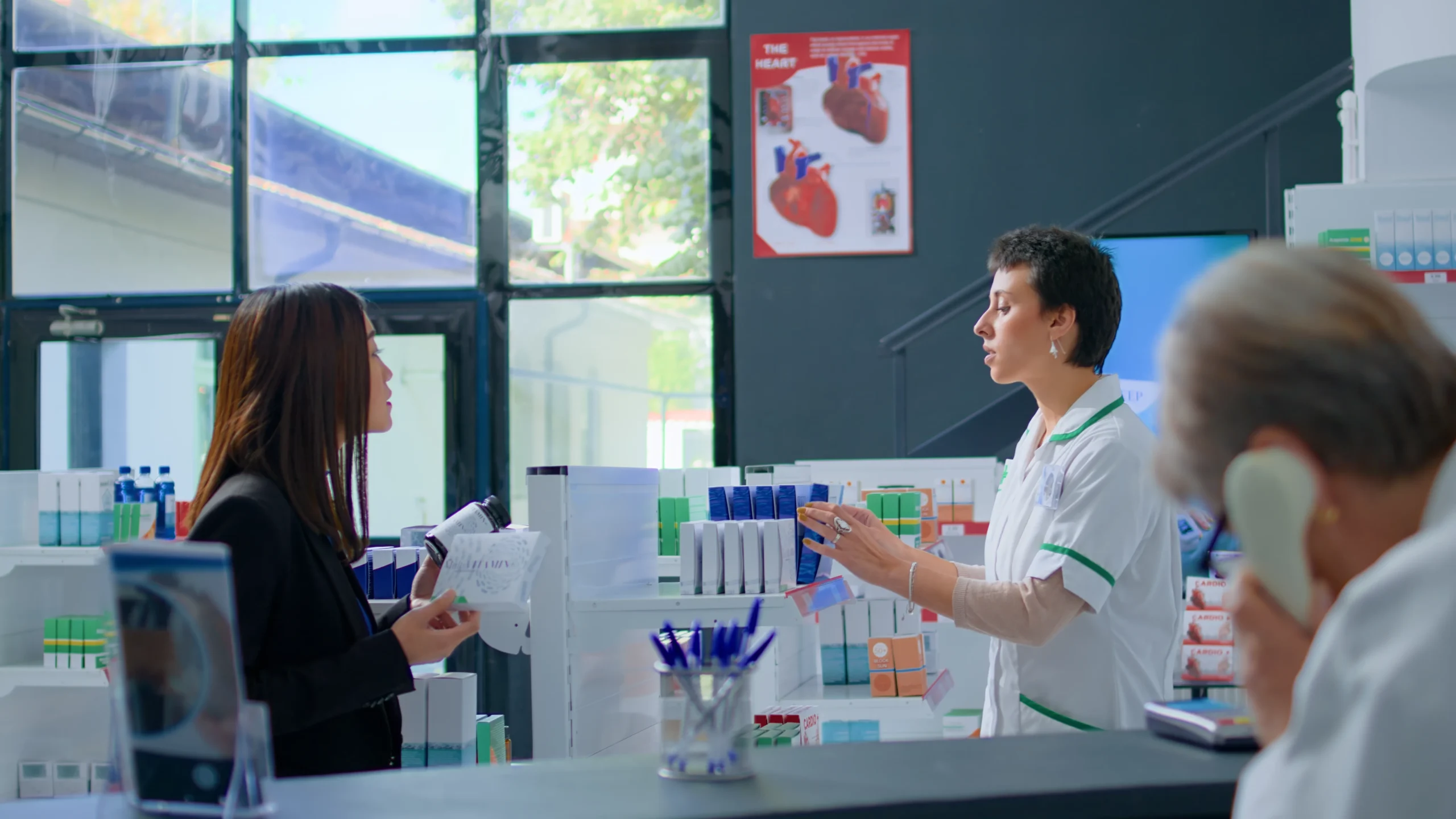 Retail pharmacist referencing real-time medication details via enterprise drug database integration.